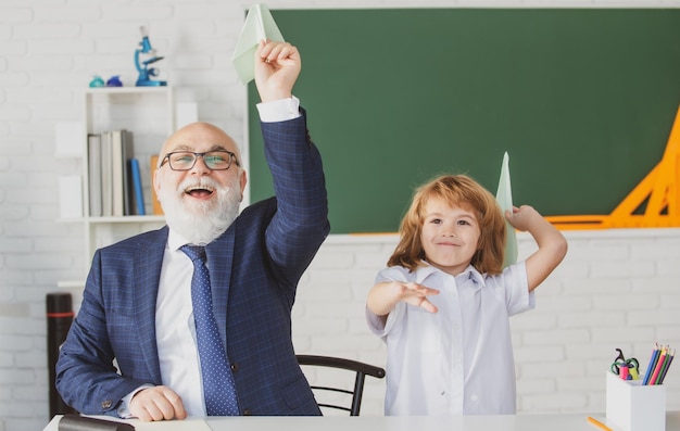 Grandfather helping to grandson with school assignment Developing caring learners who are actively growing and achieving Old man pedagogue and pupil having fun