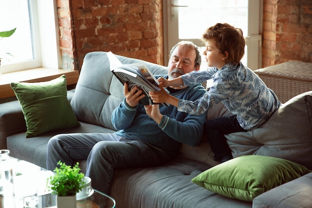 Grandfather and his grandson spending time insulated at home, having fun