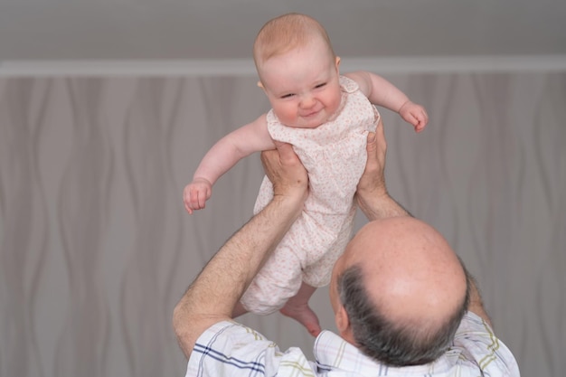 Grandfather holding a caucasian 8 month baby girl