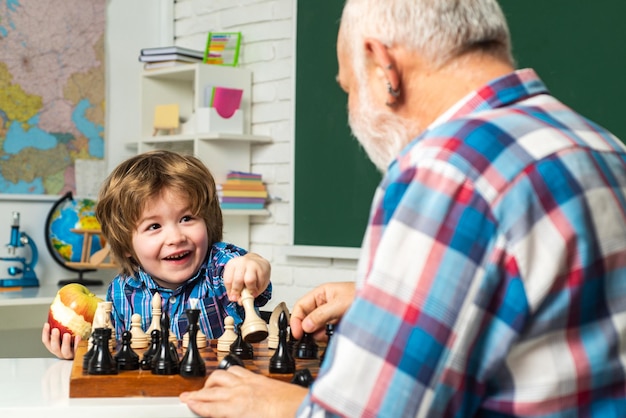 Grandfather son playing chess happy men generations family old grandfather and cute little boy grand