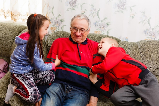 grandfather spends time with grandchildren in the living room