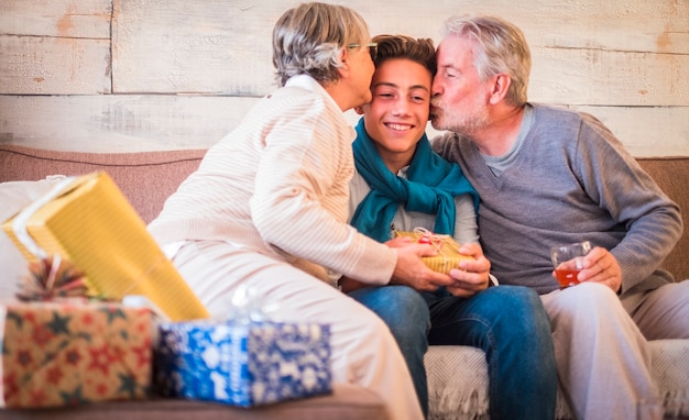 Grandfathers kiss grandson at home in christmas eve celebration together