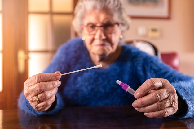 Grandma holding a cotton swab for nose to collect a possible positive COVID19