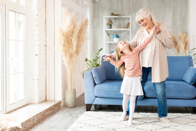 Grandma with girl at home having fun