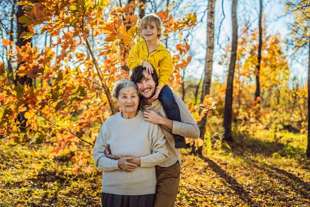 Grandmother and adult grandson hugging in autumn park.