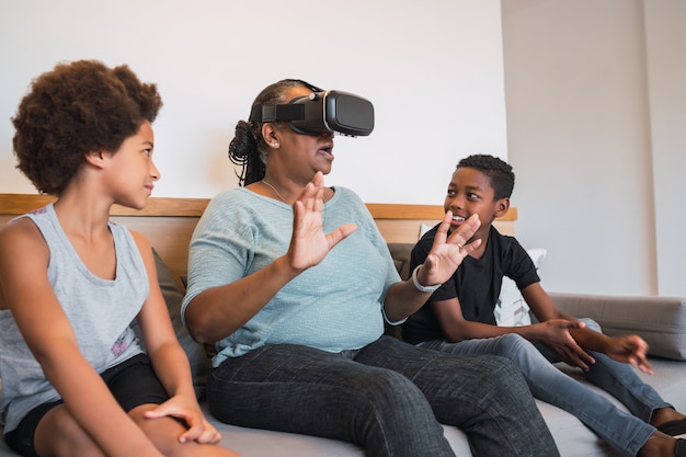 Grandmother and grandchildren playing together with VR glasses.