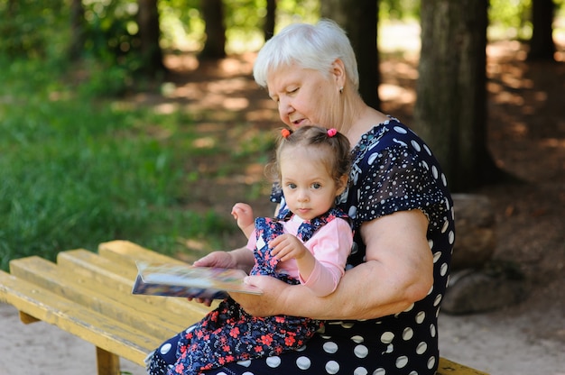 Grandmother and granddaughter reading the book in the park