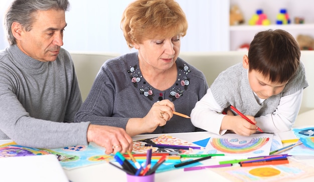 Grandmother, grandfather and grandson spend time together. Symbol of the family.