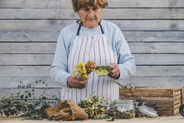 Grandmother makes tea with medicinal herbs Selective focus