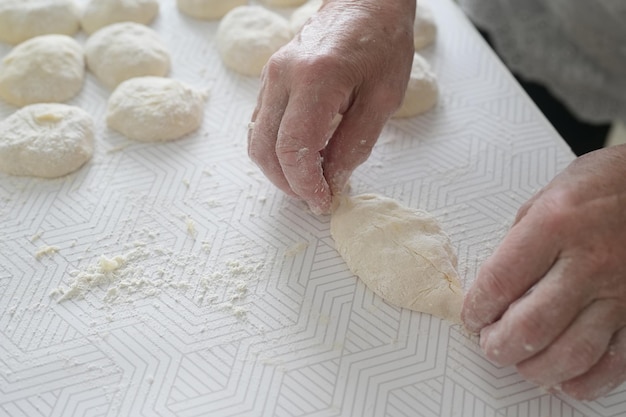 Grandmother's hands closeup An elderly woman cooks pies in the kitchen homemade baking