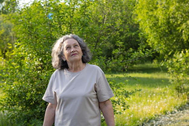 Grandmother walks in the park and looks up Retirement age