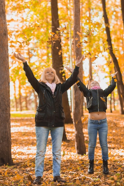 Grandmother with granddaughter in autumn park generation and family concept