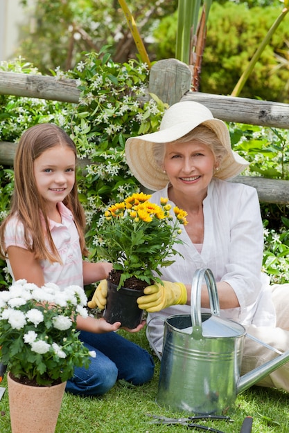 Grandmother with her granddaughter working in the garden