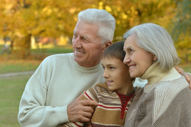 Grandparents and grandson together in autumn park