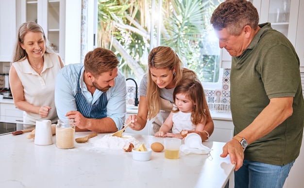 Grandparents parents and child baking in kitchen have fun bond and learning together Big family love and mom and dad teaching girl to cook bake and develop chef skills with grandpa and grandma