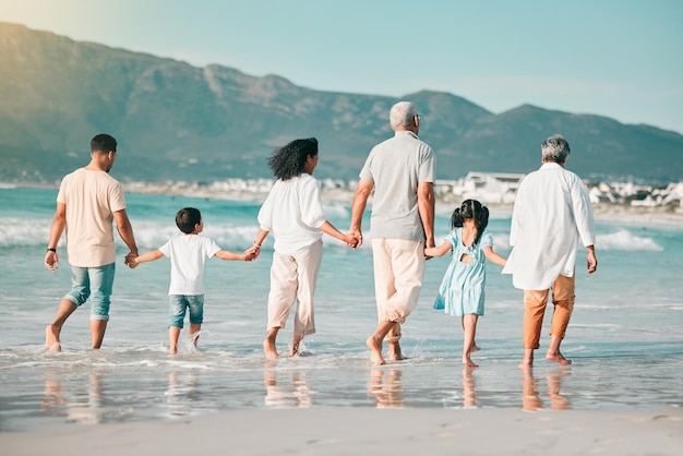 Grandparents parents or children holding hands at beach as a big family for holiday vacation travel together Grandfather grandmother or back of mom walking with dad love or kids at sea to relax