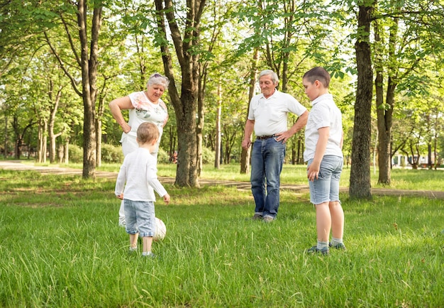 Grandparents with his little cute grandchildren playing football