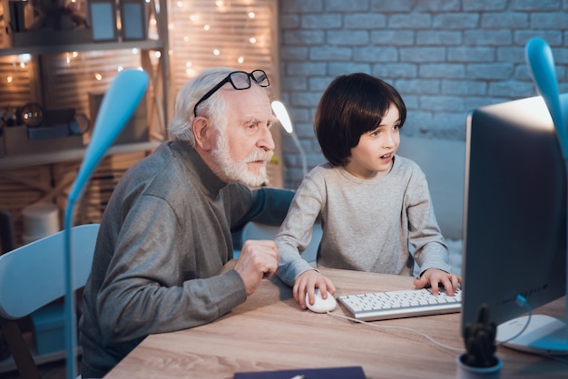 Grandson Teaching a Grandpa How to Use Computer