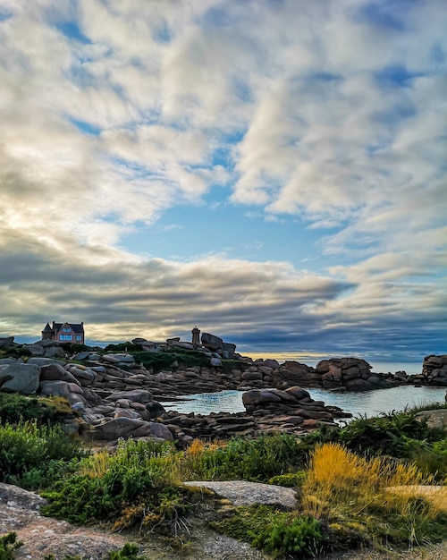 Granite Coast in Brittany near Ploumanach, France. Ploumanach Mean Ruz lighthouse red sunset in pink granite coast, Perros Guirec, Brittany