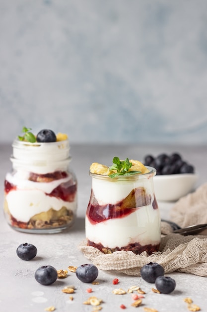 Granola, blueberry and banana greek yogurt parfaits in mason jars 