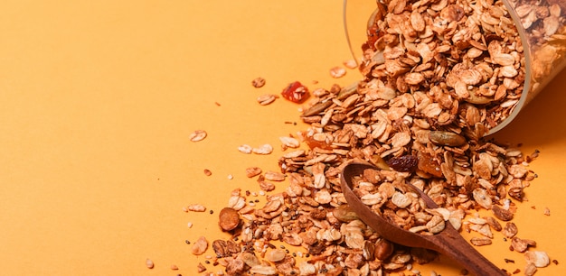 Granola in a glass jar on a yellow background