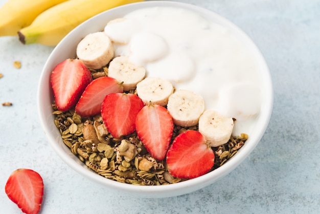 Granola, oatmeal with milk, banana and strawberry 