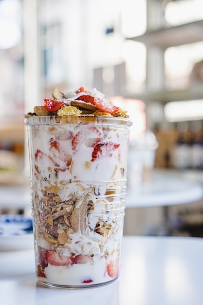 Granola with fruits and yogurt in a glass cup.