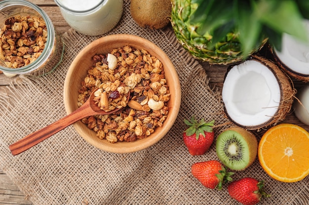 Granola with Greek yoghurt and fruit on a wooden background in a rustic style