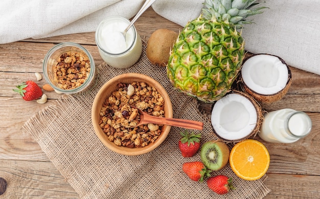 Granola with Greek yoghurt and fruit on a wooden background in a rustic style