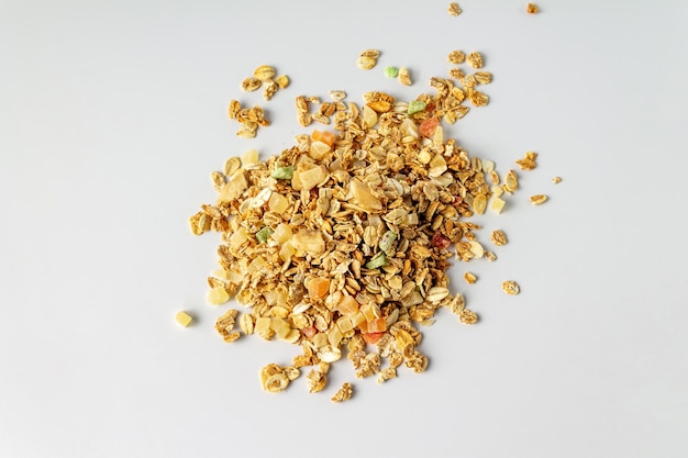 Granola with pieces of dried fruits and pumpkin seeds on a white background