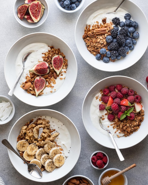 Granola with yogurt berries fruits and nuts on a concrete background top view