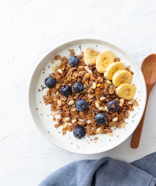 Granola with yogurt, blueberries, nuts, banana and honey. Muesli. Healthy eating. Vegetarian food.