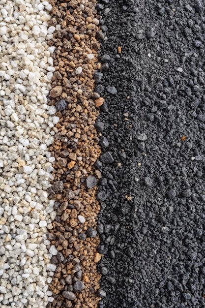 Granular soil texture with gravel particles small stones black gray and white grains Closeup top view Gray asphalt pattern Bitumen road texture