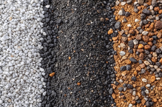 Granular soil texture with gravel particles small stones black gray and white grains Closeup top view Gray asphalt pattern Bitumen road texture