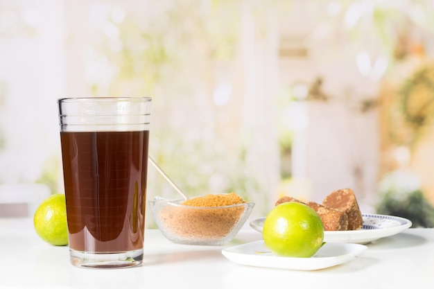 Granulated panela and agua de panela and lemon or sugar cane sweets and lemon in the kitchen typical food of Colombia