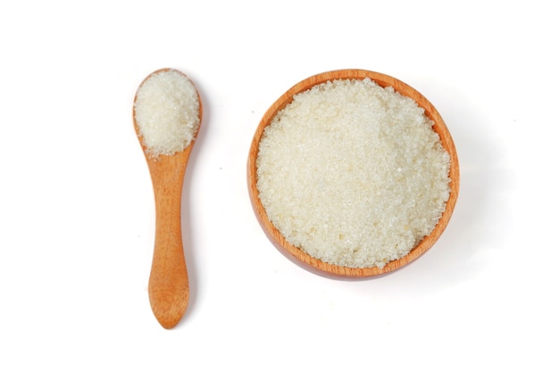 Granulated sugar with wooden bowl and spoon on white background,Top view