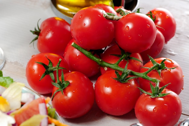 Grape of cherry tomatoes on white wooden table