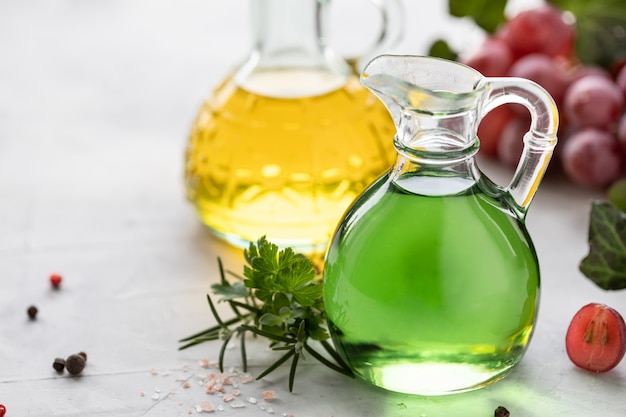 Grape seed oil in a glass bottle with a bunch of grapes.