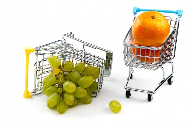 A grape in shopping cart isolated on white background. Ripe tasty green grapes in shopping cart. Grape trading concept. Online shopping concept. Cart and grape over a white background.