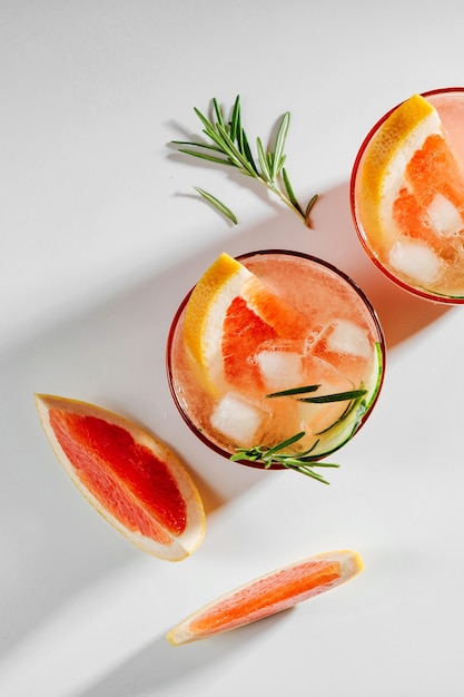 Grapefruit and Cucumber Gin Cocktail on elegant glasses on white background with shadows