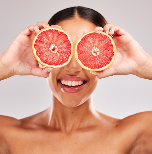 Grapefruit skincare and wellness of a woman holding fruit skincare and vitamin c for face glow Model with fruits for health cosmetic eye treatment and healthy diet nutrition food with beauty