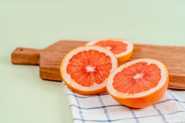 Grapefruit slices on wooden board on a green background The concept of healthy nutrition vitamin