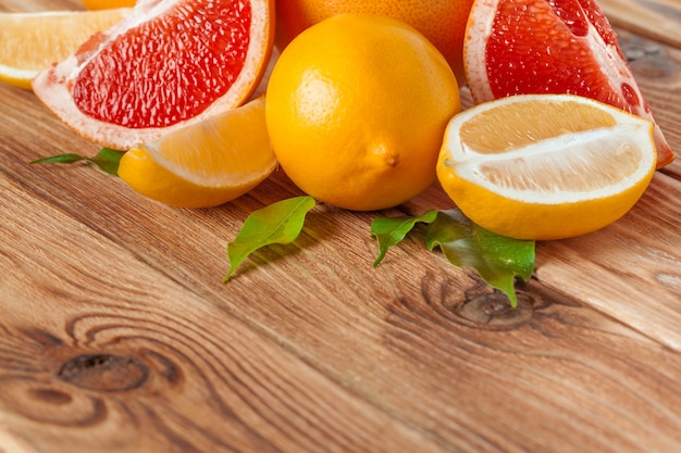 Grapefruit with slices on a wooden table.