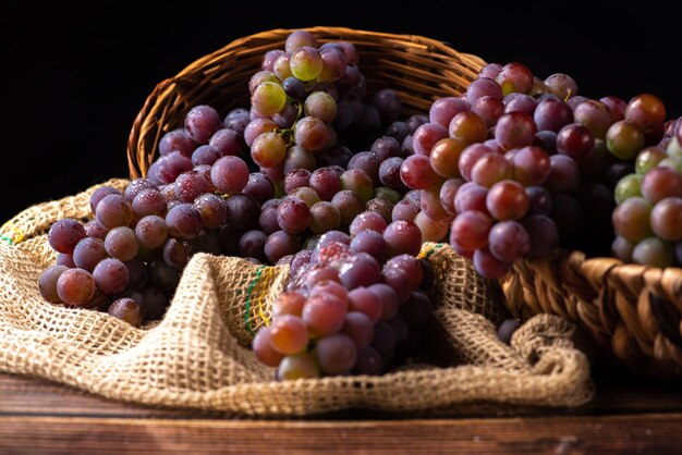 Grapes basket with beautiful grapes and rustic fabric on rustic wood selective focus