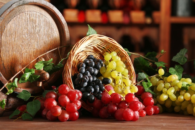 Grapes in bowl and barrel on wooden table