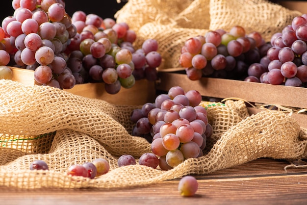 Grapes details of beautiful grapes in a rustic box on a rustic wooden table selective focus