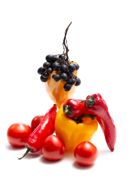 Grapes peppers and tomatoes on a white background