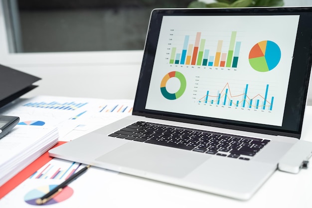 Graph data in project in laptop computer in office to analyzing financial reports finance and business concept