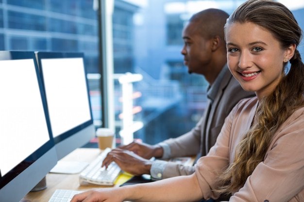 Graphic designer working at desk with colleague