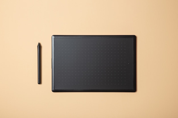 Graphics tablet and stylus on a cream background